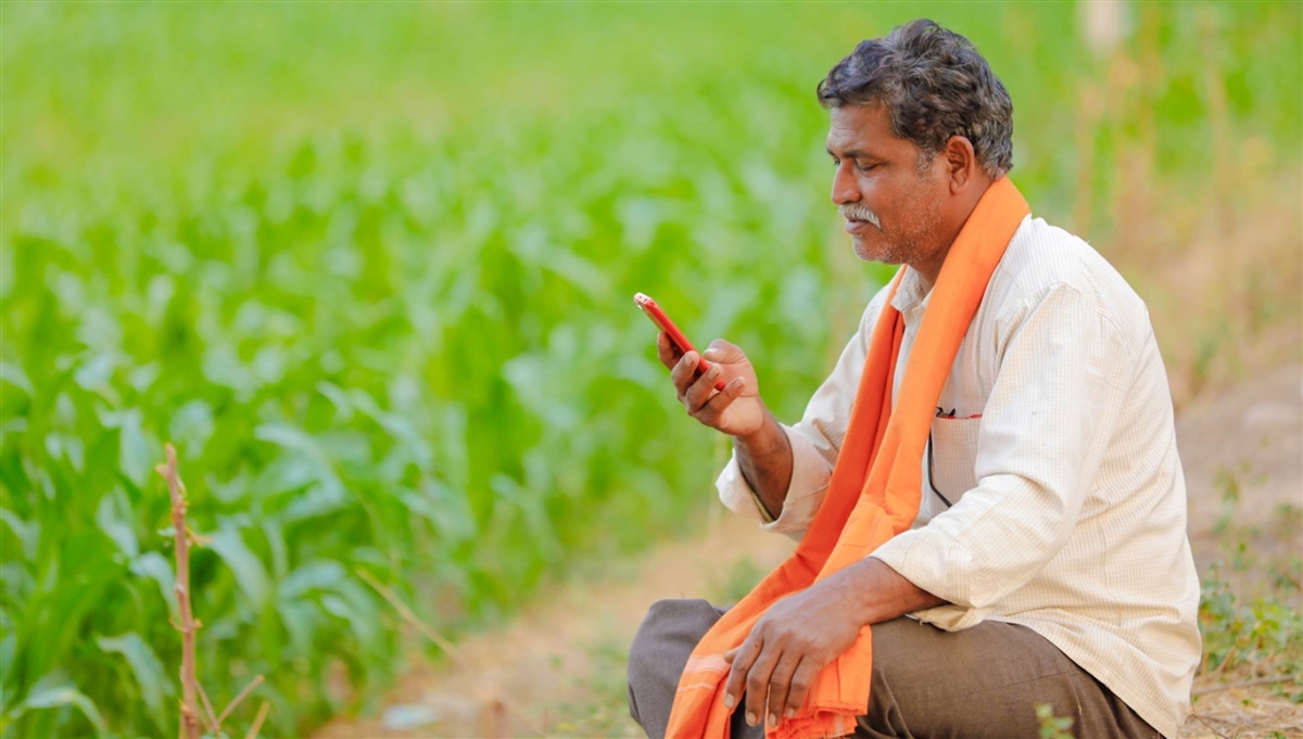 An Indian farmer uses a mobile phone.